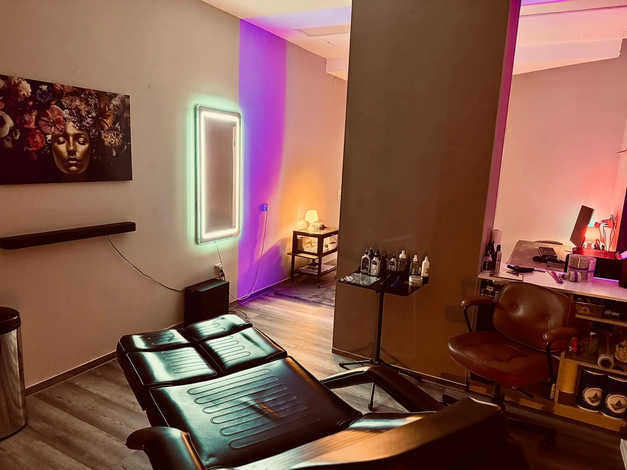 Tattoo-Liege im Studio, Neon-Spiegel und violettes Licht
